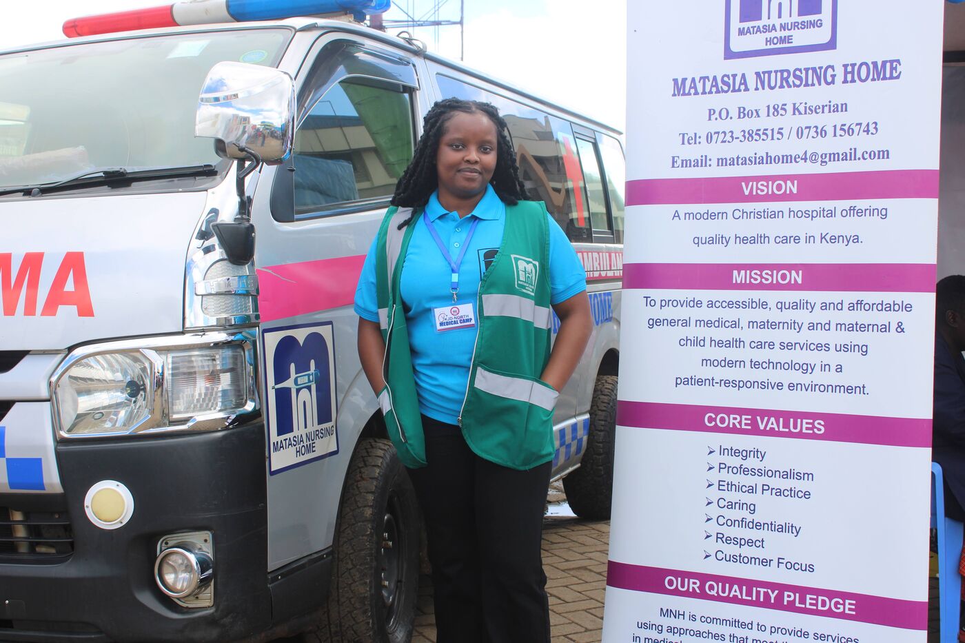 A Matasia nurse standing beside the hospital ambulance